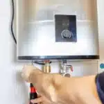 A Clear Choice technician installing a new water heater in an Englewood home